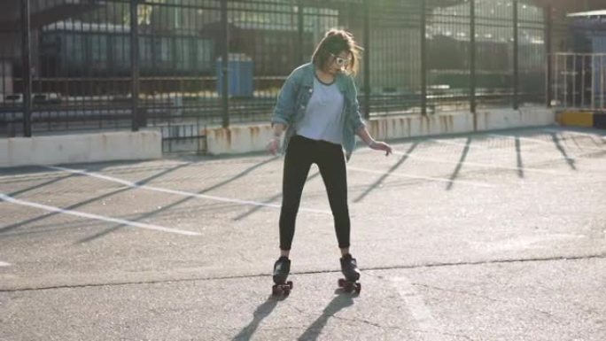 迷人美丽的年轻女子在街上溜冰跳舞。城市背景，慢动作120fps