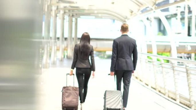 Businessman and woman walking with suitcase go to 