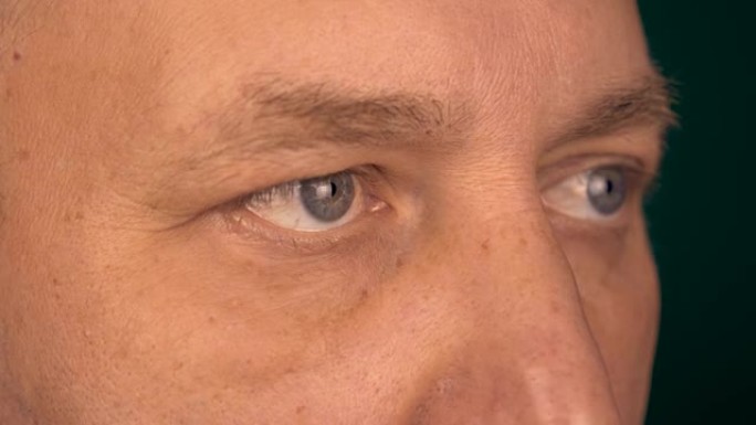 从近距离观察一个人的固定视野。男性的眼睛看着同一点。半翻描绘男性脸极端特写。