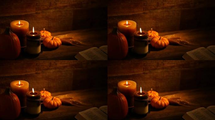 带蜡烛的秋天南瓜和木制背景上的开放圣经