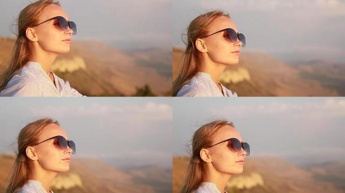 日落时太阳下墨镜的女孩