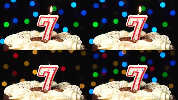 蛋糕上的7号-七个生日蜡烛燃烧-最后吹灭。彩色模糊背景