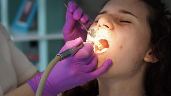 牙科涡轮钻用于龋齿保护。蛀牙治疗。牙医诊所的女性患者正在治疗牙齿