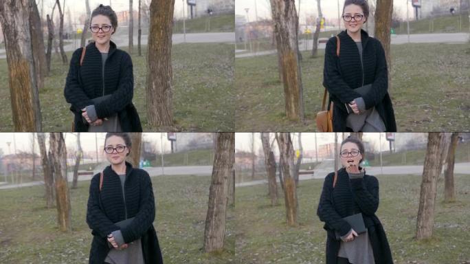 一个女人拿着一本书在树丛之间行走并看着相机的慢动作镜头