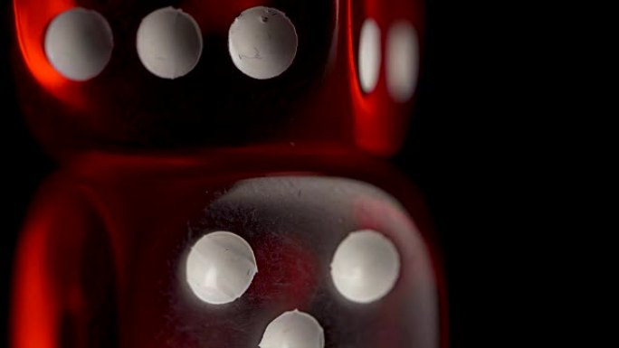 黑色背景上的两个红色赌场丁。带骰子和丝带的铅球眼镜。风险概念-在黑色木制背景下玩骰子。用骰子玩游戏。