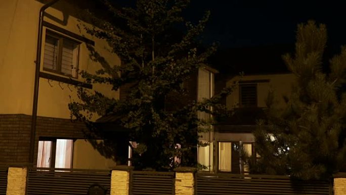 住宅小区的松树智能房屋当主人晚上回家时打开灯