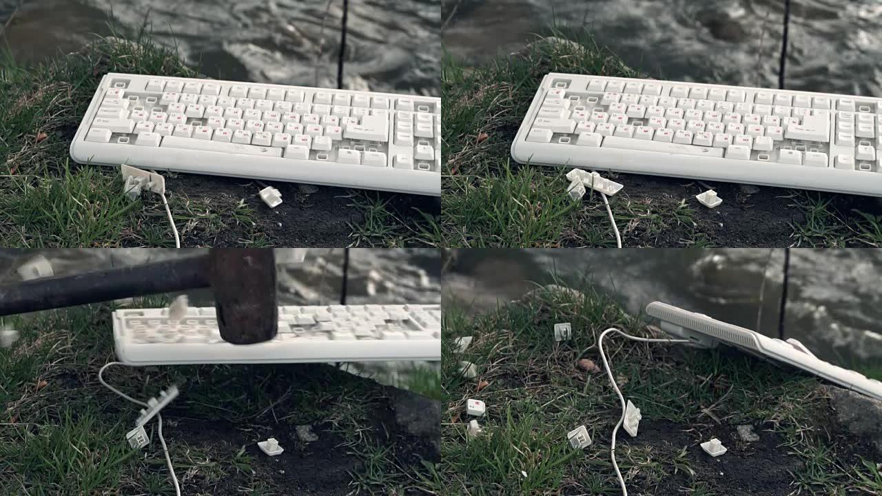 锤子砸碎了电脑键盘。自然界中坏掉的电脑键盘。技术概念对世界的不利影响