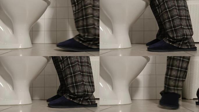 穿着睡衣和拖鞋的男性腿的特写镜头上厕所