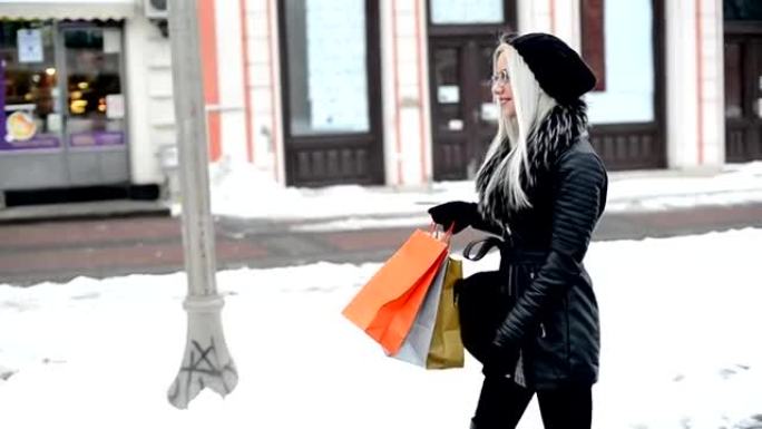 在城市里带着购物袋的快乐年轻金发女人
