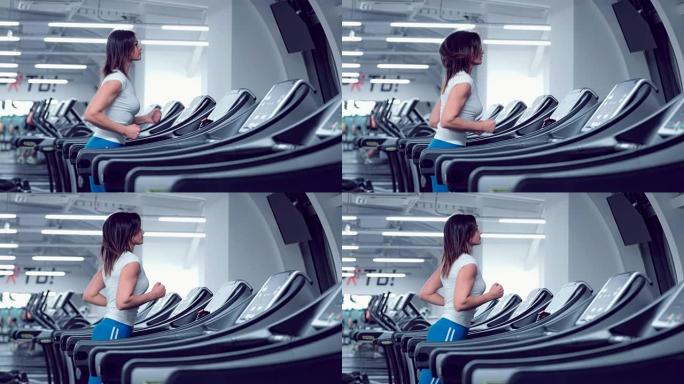 Adult woman runs on treadmill at the fitness centr