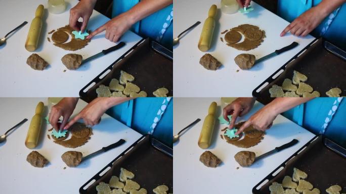 脆饼饼干的制备。一个有塑料邮票的女人在饼干上贴上图案。