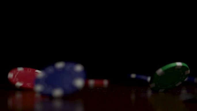 掉落的扑克筹码孤立在黑色背景上。掉落的扑克筹码孤立在黑色背景上。彩色扑克筹码落在黑色背景上的桌子上。