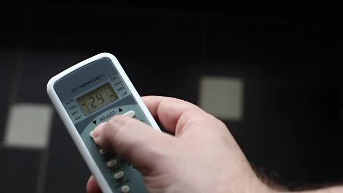用空调遥控器改变室温。夏季炎热天气下的空调和遥控器