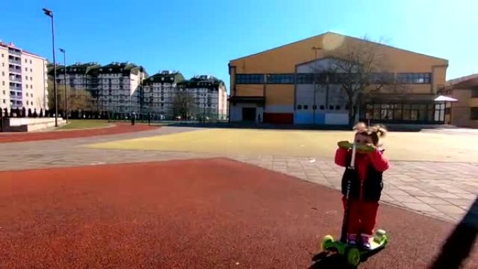 快乐可爱的小女孩骑踢踏板车在公园