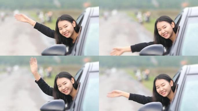 美丽的亚洲女人微笑着享受着。开车上路旅行