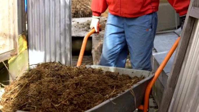 一个人用手推车搬运肥料。
