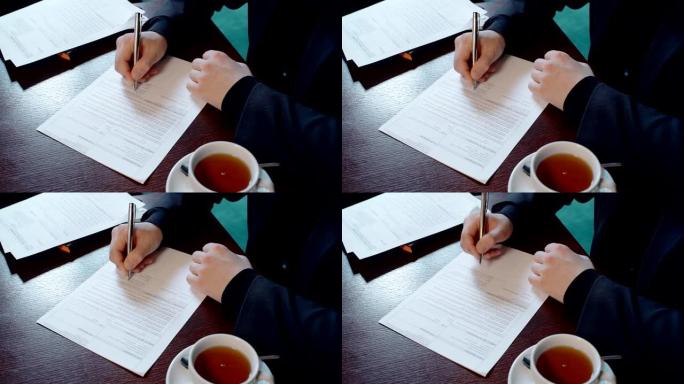 成功的商人正在签署合同，坐在餐厅的桌子上