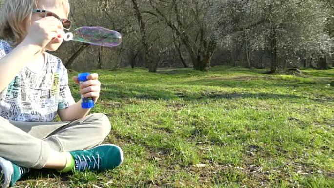 晴天玩肥皂泡的小男孩。