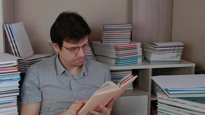 年轻的布鲁内特人戴上眼镜，坐在书里看书。