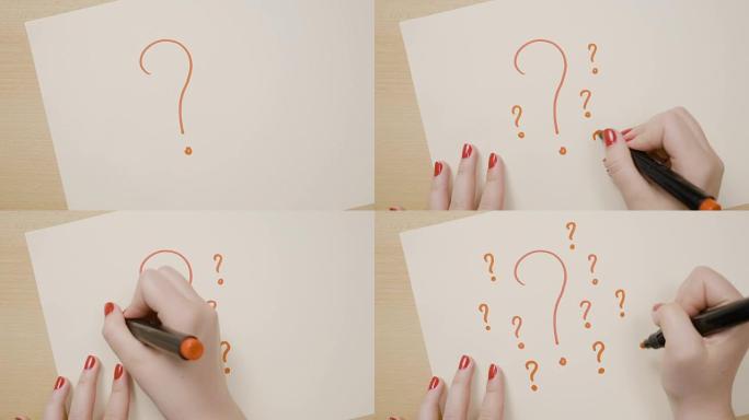 红色指甲的女性手在带有橙色标记的白纸上画了许多问号