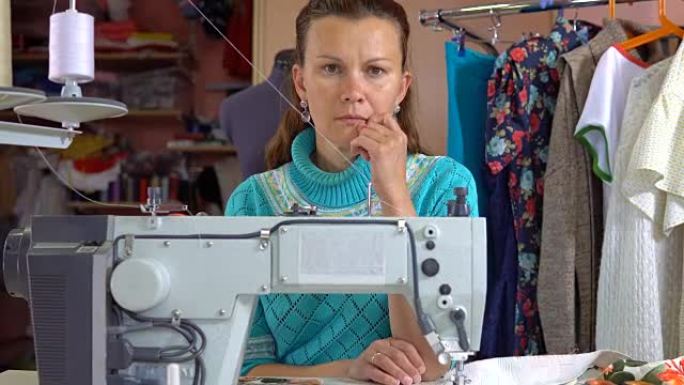 女裁缝坐在缝纫工作室的工作场所。