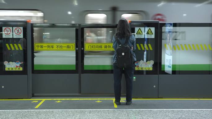 孤独的女孩背影在地铁站等候