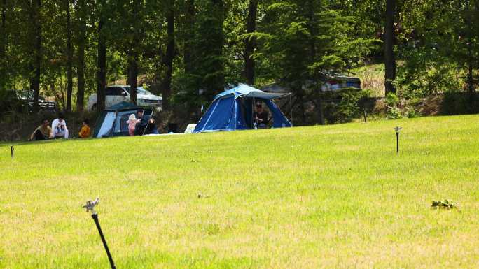 游客在露营地搭帐篷度假享受大自然