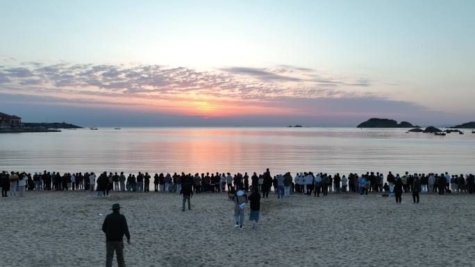 航拍威海半月湾看日出的人群