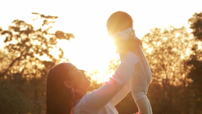 母婴亲子夕阳下的妈妈手举孩子视频