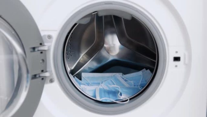 医用口罩放在洗衣机里。洗衣机装载。洗衣