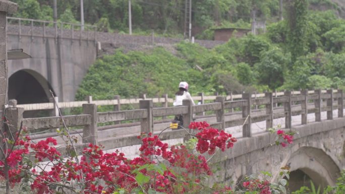 女子骑着MINI摩托车过桥