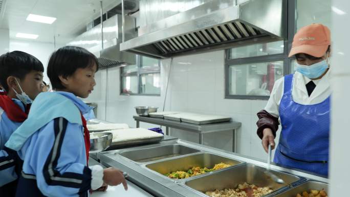 希望小学学生食堂排队打饭