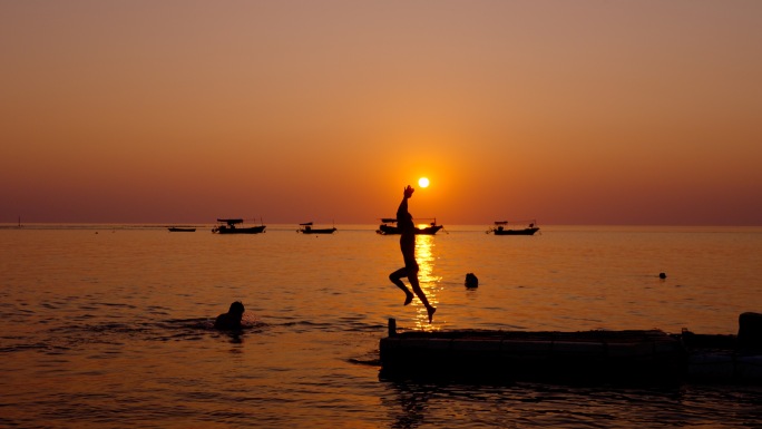 唯美海边日落夕阳下游泳玩水的小孩子