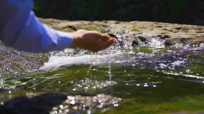 男人阳光下林间山泉水小溪流手捧水