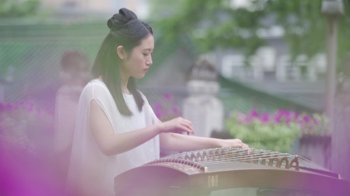 美女在雨中院落弹奏古筝