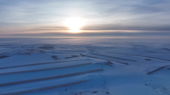 航拍冷空气笼罩的苍茫雪原夕照