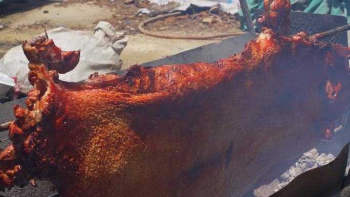 中国一位烧烤师傅正在用炭火烤整只脆皮烧猪