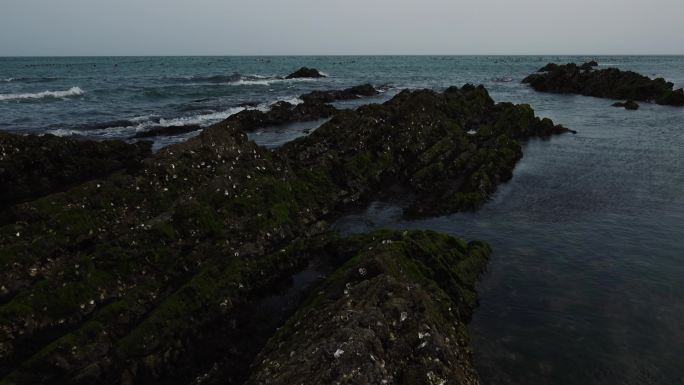 升格拍摄蓝色的海面海浪浪花被风吹散的浪花