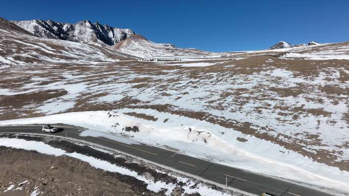 西藏雪山国道上的越野车