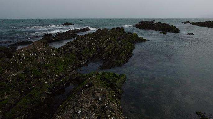 升格拍摄蓝色的海面海浪浪花被风吹散的浪花