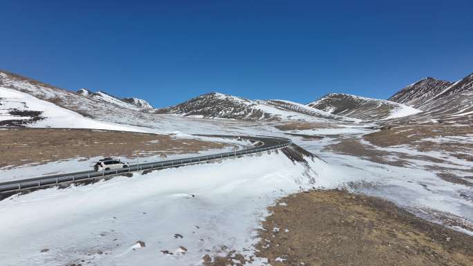 西藏雪山国道上的越野车