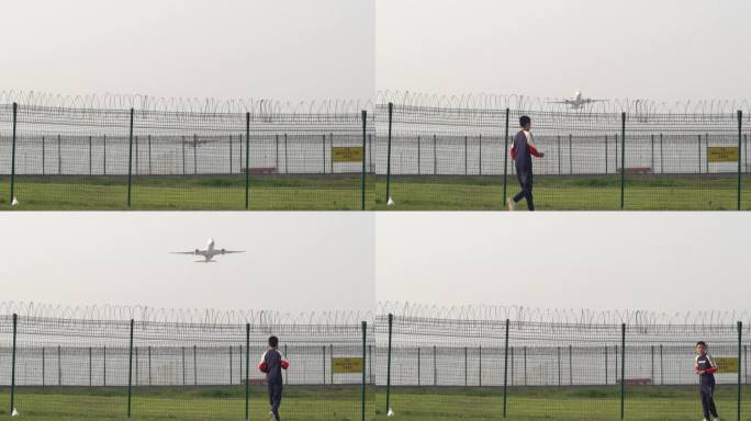 一名男孩跑到飞机场外的围栏处看飞机起飞