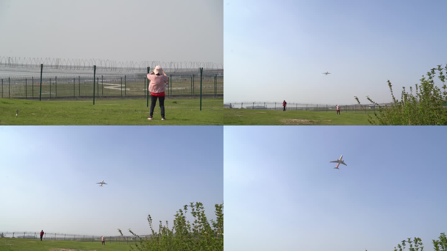 透过机场围栏飞机飞过游客拿手机拍照