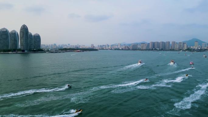 航拍海南三亚湾海面上行驶的游艇与摩托艇