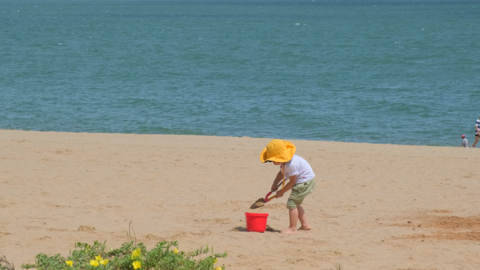 海边小孩玩沙子，滑翔伞