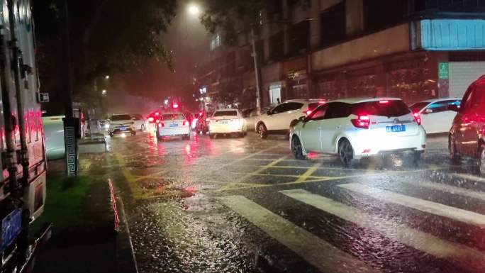 暴雨城市汽车通过积水路面夜晚强降雨塞车