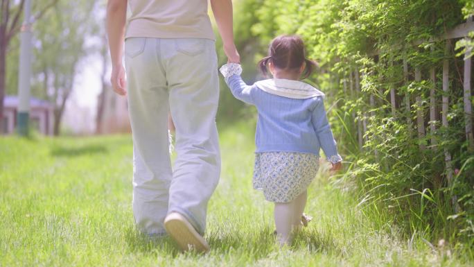 妈妈和孩子在草坪上散步