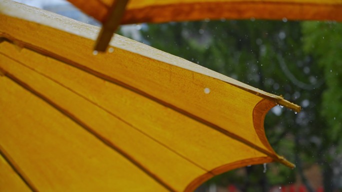 雨点落在黄色伞面