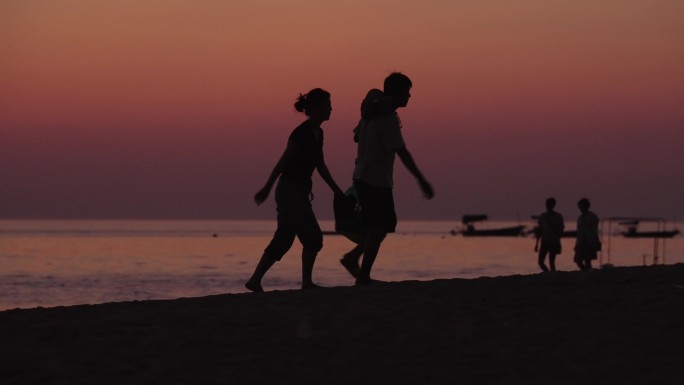 唯美海边日出日落散步的夫妻