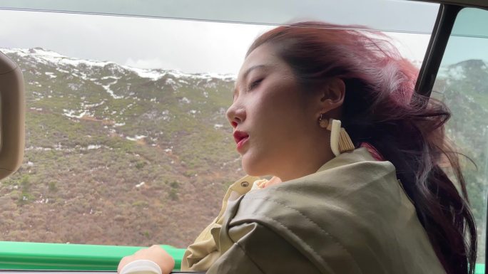 旅行中美女爬车窗休息看风景实拍
